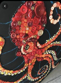 an octopus made out of buttons on a black surface