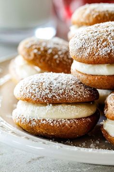 several donuts with frosting and powdered sugar on top are sitting on a plate