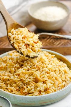 a wooden spoon scooping rice out of a bowl