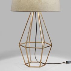 a lamp that is sitting on top of a white surface with a light bulb plugged in