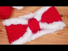 a red and white knitted bow tie laying on top of a wooden floor