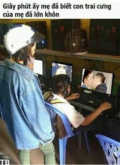 a man sitting in front of a computer monitor next to another person on a chair