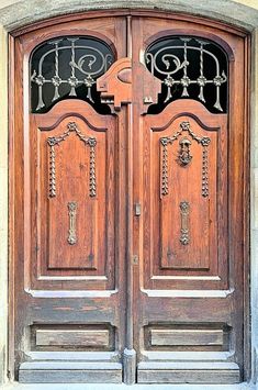 two wooden doors with wrought iron designs on them