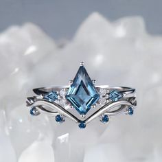 a blue topazte and diamond ring is displayed on a white background with snow flakes