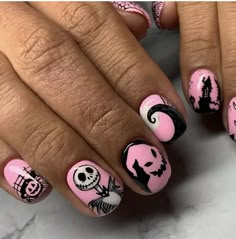 a woman's hand with pink and black halloween nail art designs on her nails