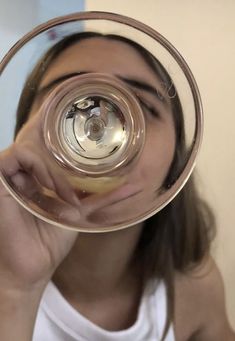 a woman holding up a wine glass to her face