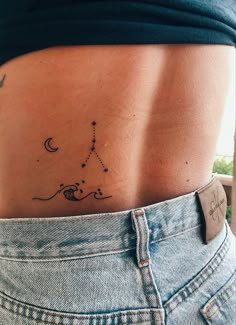 a woman's lower back tattoo with stars and moon on her left side ribcage