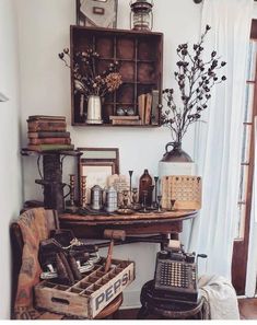 an old fashioned typewriter sitting on top of a wooden table next to a window