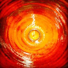 an orange and red swirl with a yellow ring in it's center is seen from above