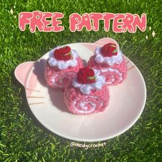 two crocheted baby booties sitting on top of a plate in the grass