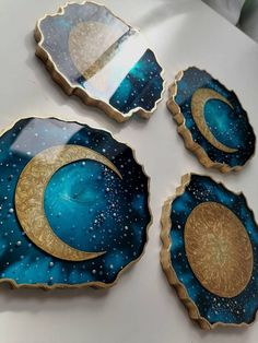 three plates with gold and blue designs on them sitting on a table next to each other