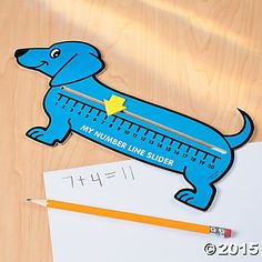 a blue dog with a ruler on it's back sitting next to a pencil