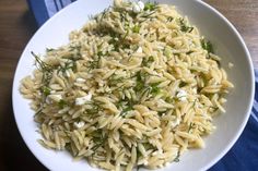 a white bowl filled with pasta and herbs