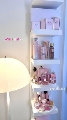 a white shelf filled with lots of personal care items next to a wall mounted light