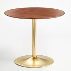 a round wooden table with a gold base