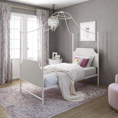 a white canopy bed sitting in a bedroom next to a pink chair and window with curtains