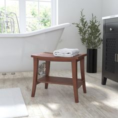 a white bath tub sitting next to a wooden table