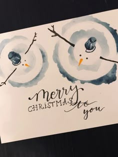 a christmas card with two snowmen on it