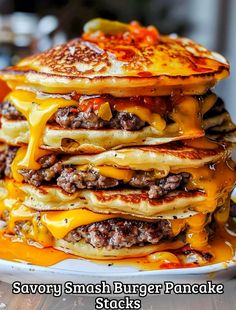 a stack of pancakes covered in cheese and meat