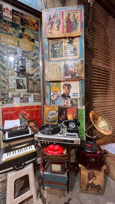 an old typewriter sitting in front of a wall covered with posters and music equipment