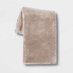 a tan towel folded on top of a white wall