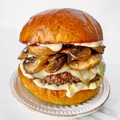 a hamburger with mushrooms and cheese on a plate