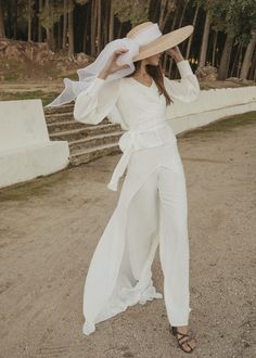 a woman wearing a white jumpsuit and hat