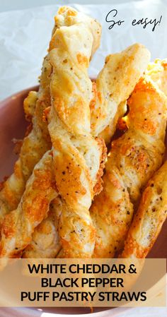 white cheddar and black pepper puff pastry straws on a plate with text overlay