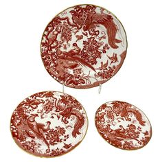 three red and white plates sitting on top of each other with birds in the middle