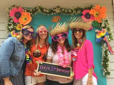 three women wearing hats and sunglasses pose for a photo in front of a sign that says zeez's 1st birthday