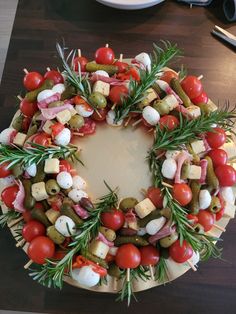 a wreath made out of different types of vegetables and meats on skewers