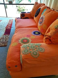 an orange couch with colorful pillows on it