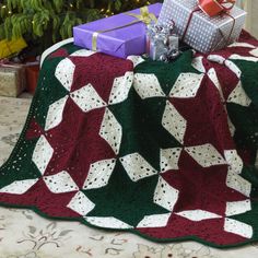 a blanket that is on top of a table next to a christmas tree and presents