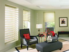 a living room filled with furniture and windows covered in roman blind shades on top of them