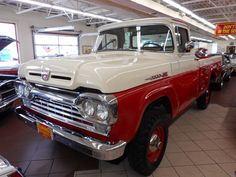 an old red and white truck in a showroom