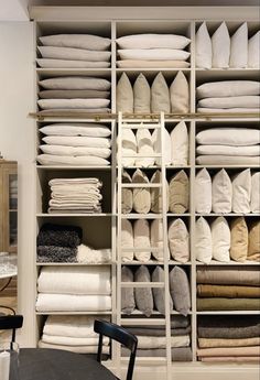 the closet is full of white linens and folded towels on shelving units with shelves