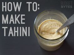 a jar filled with food sitting on top of a table next to a knife and spoon