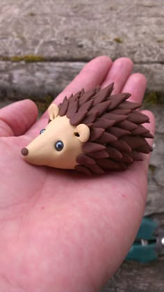 a small toy hedgehog sitting on top of someone's hand