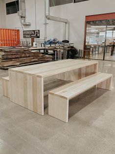 a wooden bench sitting in the middle of a room next to some tables and chairs