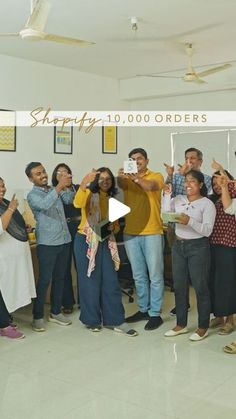 a group of people standing around each other in front of a sign that reads shopify 10, 000 orders