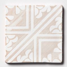 a white and beige tile with an intricate design on the bottom corner, in square shape