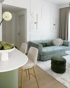 a living room filled with furniture and a white table in front of a large window