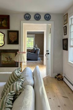 a living room filled with furniture and pictures on the wall