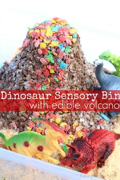 a close up of a cake in a box with dinosaurs on it and the words dinosaur sensory bins with edible volcanos