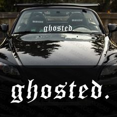 a black sports car with ghosted written on the hood