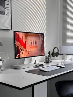 Modern and minimalist workspace featuring a large monitor displaying artistic content, a monochrome theme with black and white colors, and sunlight filtering through blinds. The desk is equipped with a Mac mini, wireless keyboard, and various tech accessories neatly arranged, complementing a stylish and functional setup Minimalist Desk Design, Minimalist Desk Setup, Minimalist Office Desk, Aesthetic Home Office, Monochromatic Aesthetic, Office Desk Set