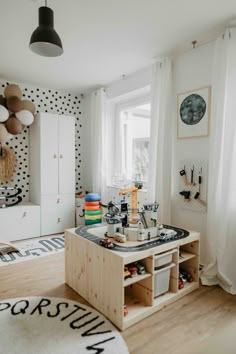 a child's room with polka dot wallpaper and wooden table in the middle