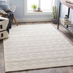 a white rug in a living room next to a window