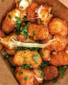 a box filled with fried food and garnished with parsley on the side