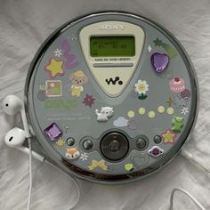 an electronic device with many stickers on it's face and earbuds